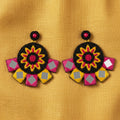 Decorative earrings with floral design on a textured surface