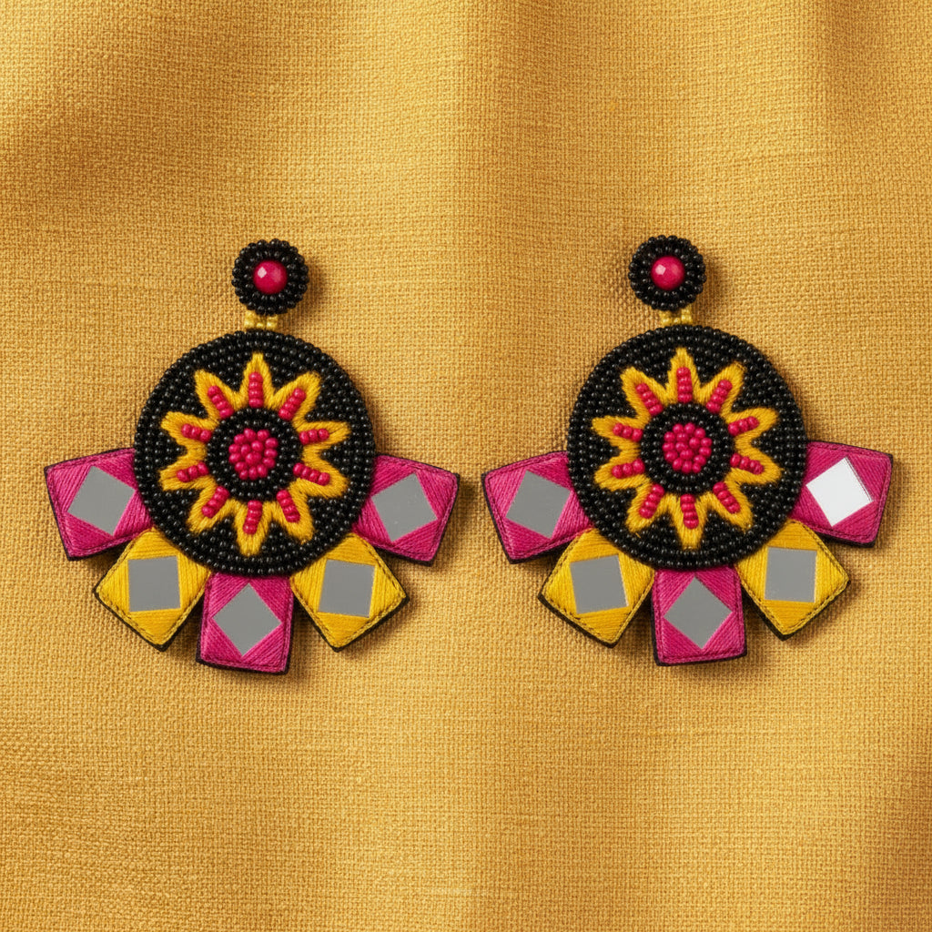 Decorative earrings with floral design on a textured surface