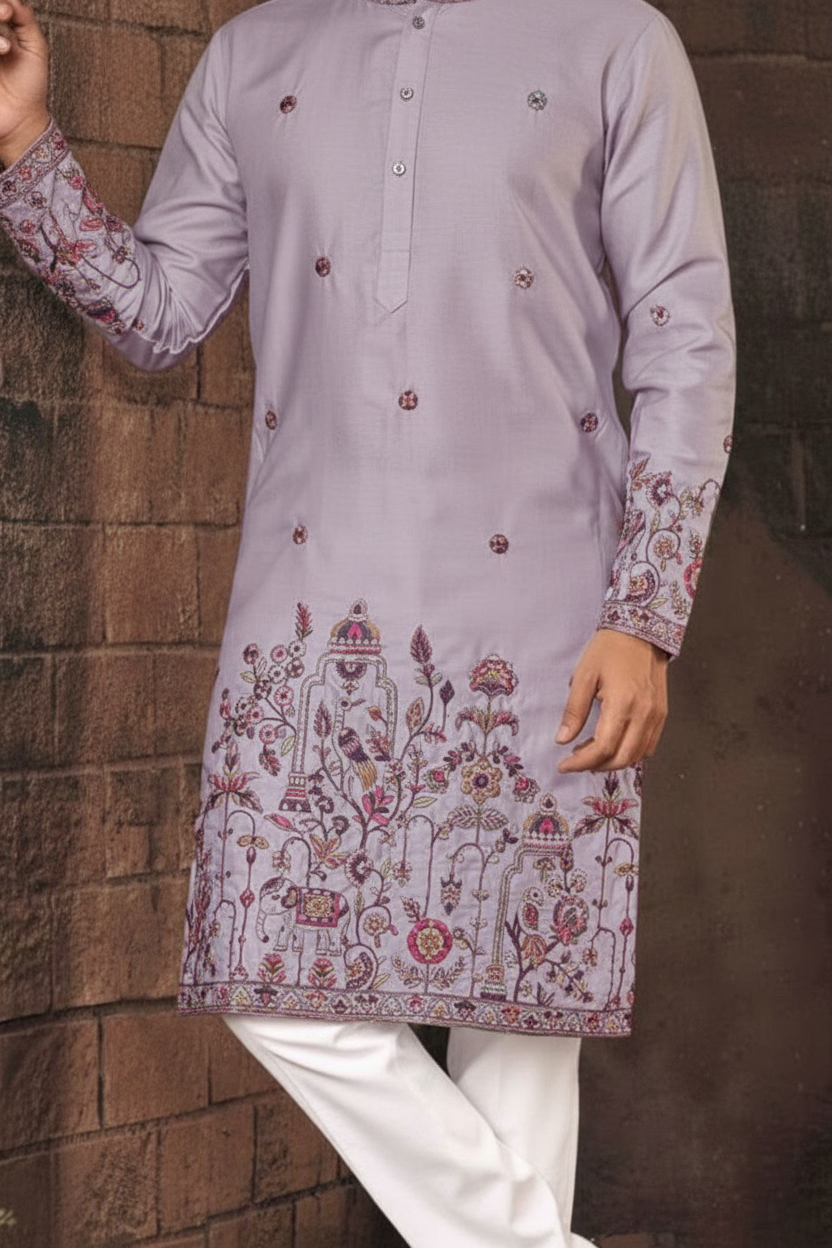 Lilac embroidered kurta with white pants against a brown brick wall.