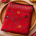 Red embroidered fabric on a woven plate with decorative elements