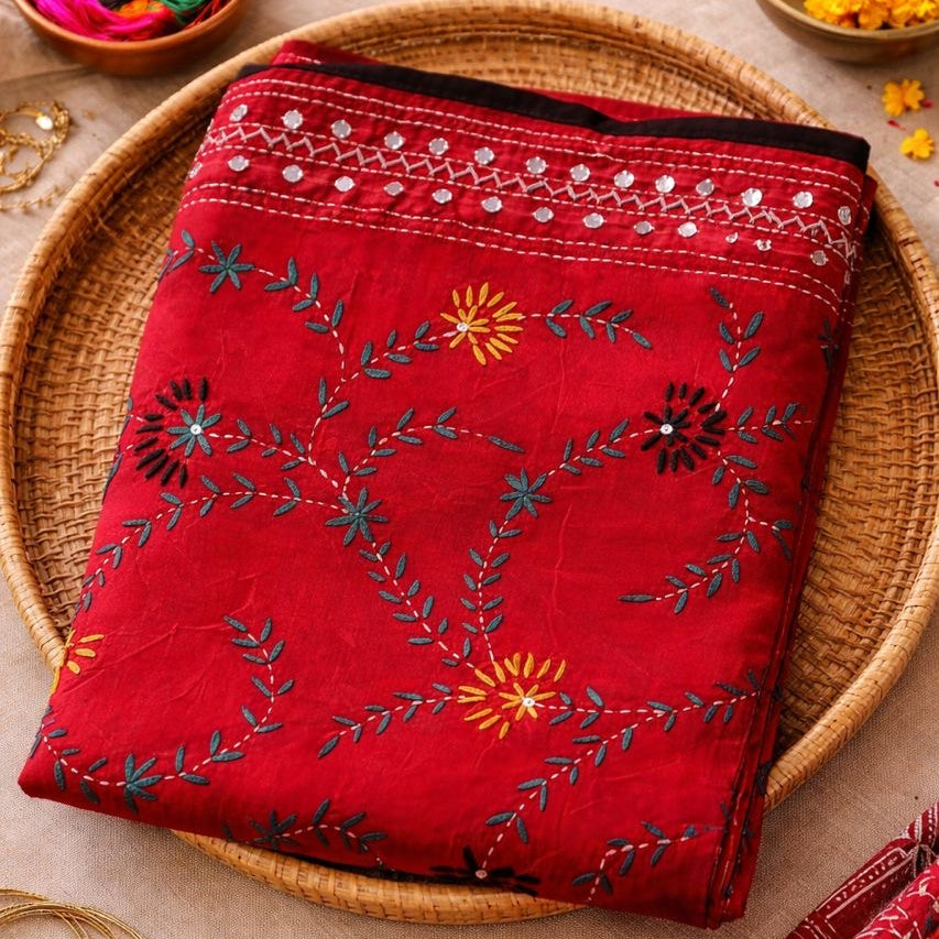 Red embroidered fabric on a woven plate with decorative elements